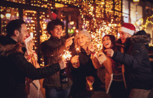Three,Couple,With,Sparklers,Enjoying,Christmas,Outdoor,Party,In,The